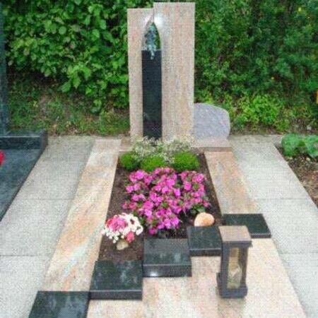 Grabmal mit Blumenbeet und Fassung aus unterschiedlichem Stein