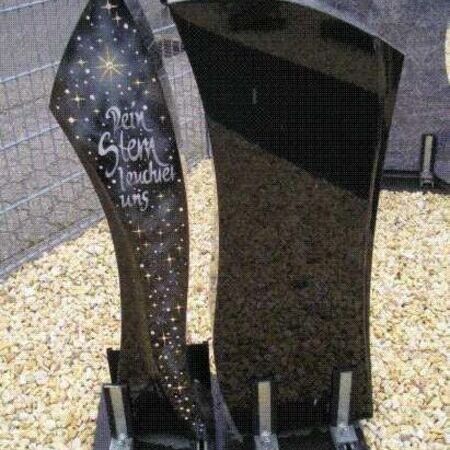 Grabmal aus dunklem Stein mit Sternenmotiv und Beschriftung